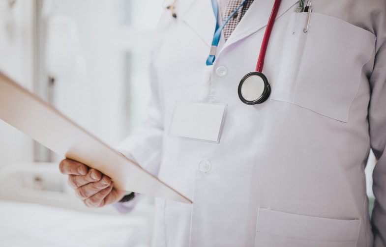 Doctor reading a patients medical chart Doctor reading a patients medical chart